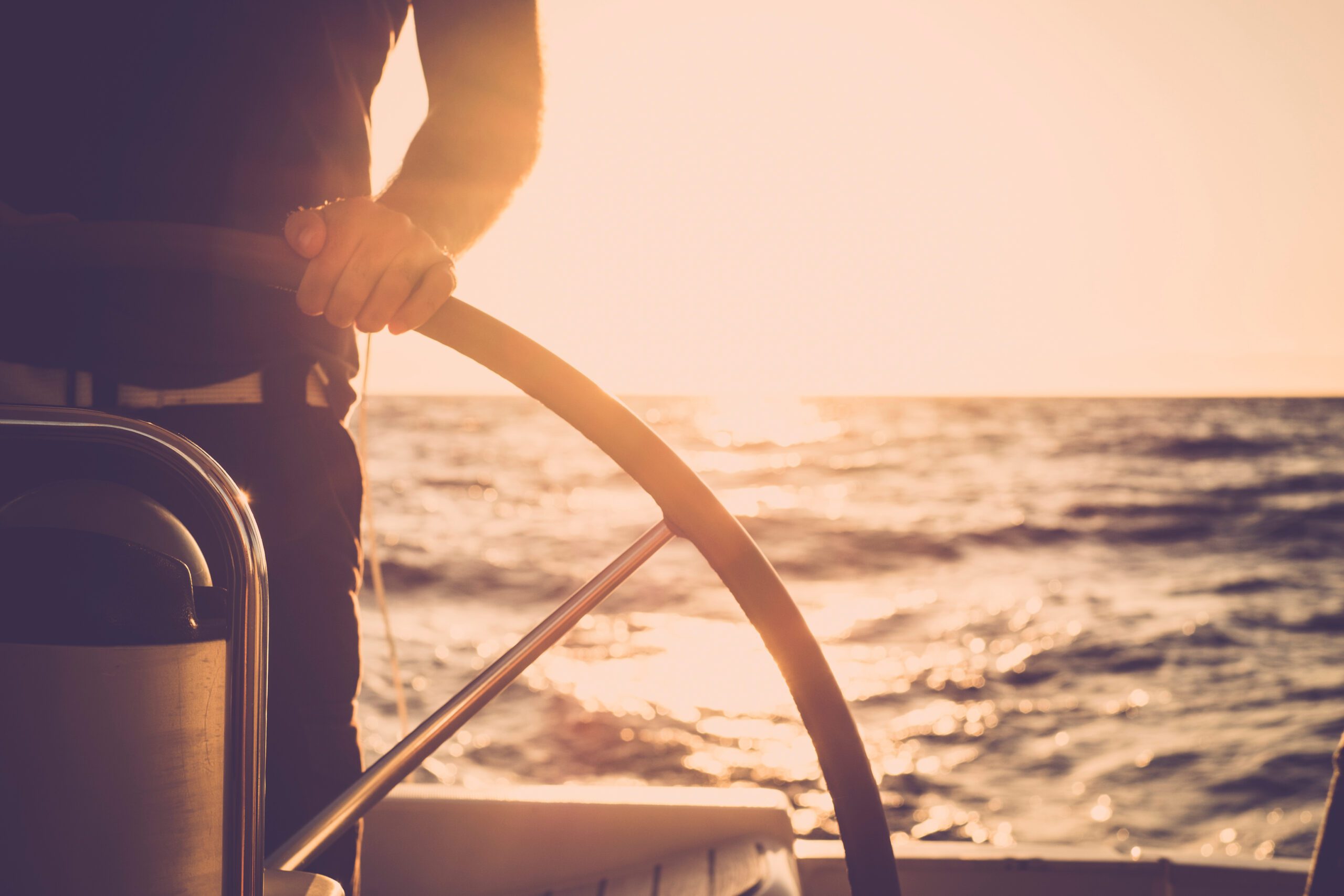 Close up of man's hand on sail boat helm